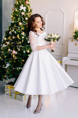The bride holds in her hands a beautiful winter wedding bouquet. The bride in a beautiful wedding dress. Winter wedding
