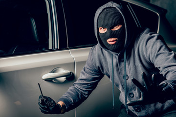 A man with a Balaclava on his head tried to break into the car. He uses a screwdriver. Hijacker,...