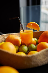 oranges and orange juice in glass on wooden table