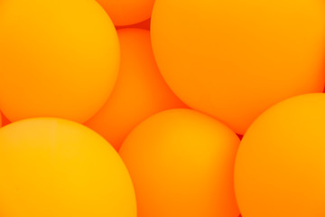 Festive composition with bunch of matte orange balloons. Macro shot, close up, background with a lot of copy space for text.