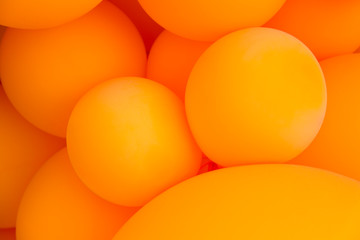 Festive composition with bunch of matte orange balloons. Macro shot, close up, background with a lot of copy space for text.