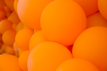 Festive composition with bunch of matte orange balloons. Macro shot, close up, background with a lot of copy space for text.