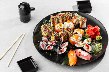 Japanese sushi set. Set of fresh tuna maki , salmon nigiri and dragon sushi rolls served on black plate close-up. Horizontal top view from above Top view flat lay. A set for a large company.