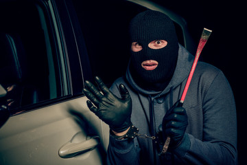 male thief is going to open the car door with a crowbar.