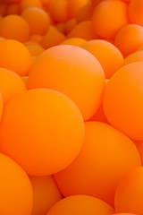 Festive composition with bunch of matte orange balloons. Macro shot, close up, background with a lot of copy space for text.
