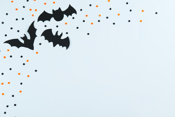 Halloween themed flat lay composition with decorative bats, on dark paper textured background with a lot of space for text. Close up, top view. - Powered by Adobe