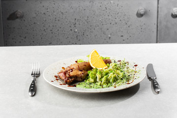 Roast duck leg with baked romanesco broccoli, lemon slice and chilli pepper on white plate, closeup. Horizontal view from above, top shot
