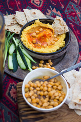 Chickpea hummus with paprika, olive oil, coriander, vegetables, pita chapati bread. Vegan food.