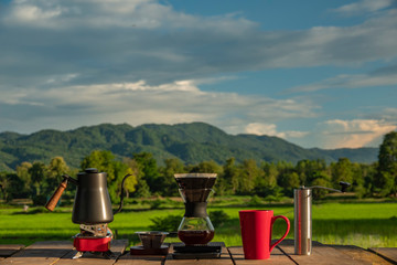Fototapeta na wymiar drip coffee with filter in morning on beautiful rice fields view