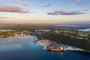 Aerial view of a container ship loading cargo in the commercial dock of Port Vila, Vanuatu capital city in the south Pacific - obrazy, fototapety, plakaty