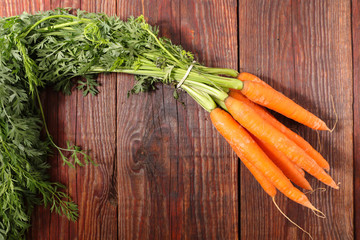 fresh carrot and leaf on wood background