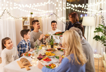 celebration, holidays and people concept - happy family having dinner party at home