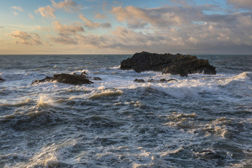 Large waves crash over rocks in stormy seas at Hartland, North Devon, England.