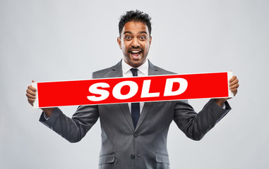 real estate business, realty sale and success concept - happy indian male realtor with red sold...