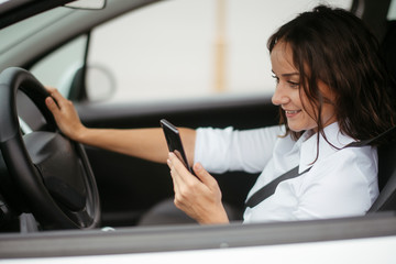 Young businesswoman in car using phone