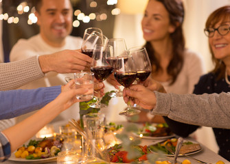 celebration, holidays and people concept - happy family having dinner party, drinking red wine and toasting at home