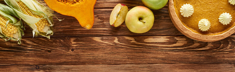 top view of pumpkin pie and seasonal vegetables served on wooden table, panoramic shot