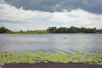 Riverbank, green algae, thunderstorm clouds