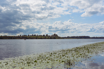 Riverbank, green algae, thunderstorm clouds