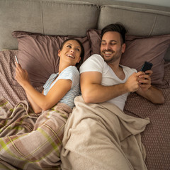 Young couple is resting in bed after work.