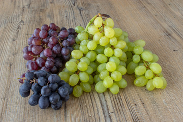 grappolo d'uva rossa e bianca su tavola di legno