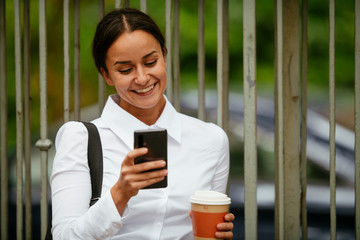 Young businesswoman using phone on coffee break