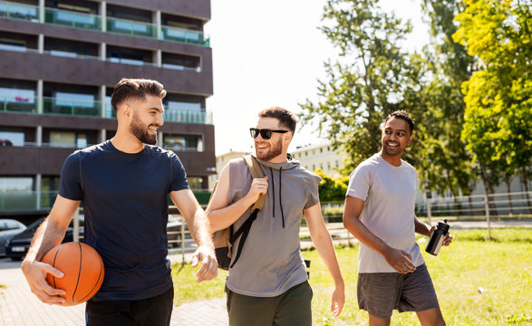 Sport, Leisure Games And Male Friendship Concept - Group Of Men Or Friends Going To Play Basketball Outdoors