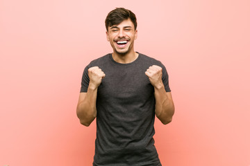 Young hispanic casual man cheering carefree and excited. Victory concept.