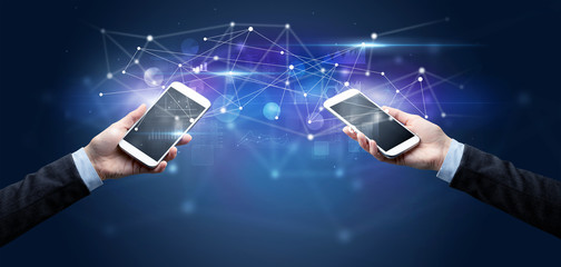 Close up of two hands holding smartphones and sharing business data
