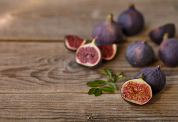 A few figs in a bowl on an old wooden background.