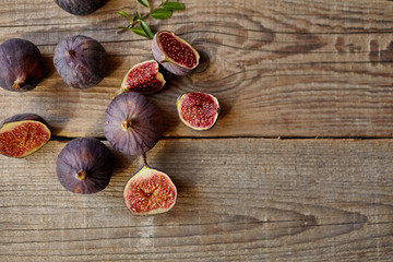 A few figs in a bowl on an old wooden background.