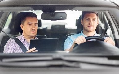 driver courses and people concept - man and driving school instructor with tablet computer in car