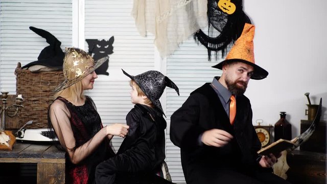 Family in halloween costumes. Happy family mother father and childboy in costumes on a celebration of Halloween. Happy laughing child boy hugging his mother in skeleton costume to halloween. Halloween