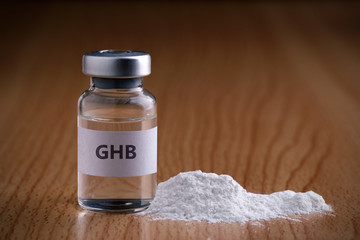 Bottle of GHB with drug powder on wooden background.GHB - obrazy, fototapety, plakaty