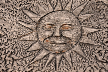 Sun carved on a wooden background stock images. Carved wooden background with sun symbol. Wooden happy sun. Decorative sun on a wooden surface. Wooden sun with face stock images