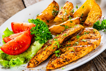 Grilled chicken fillet and vegetableson white plate