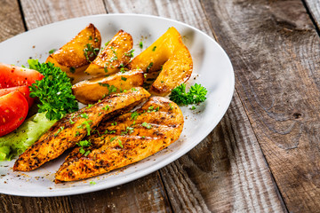 Grilled chicken fillet and vegetableson white plate