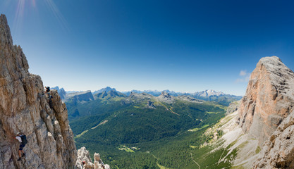 Fototapeta na wymiar panorama view of a group of mountain climbers on a steep Via Ferrata with a grandiose view of the Italian Dolomites