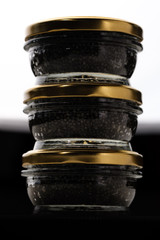 Glass jars with black sturgeon caviar.