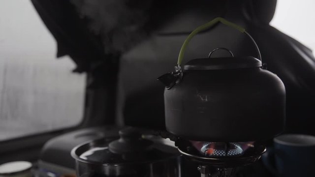 Boiling kettle on stove in camper van