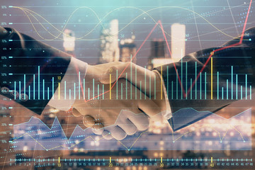 Double exposure of financial graph on cityscape background with two businessman handshake. Concept of stock market deal