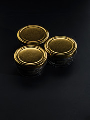 Glass jars with black sturgeon caviar.