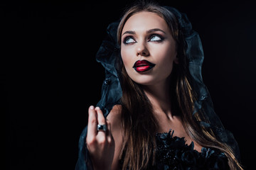 scary vampire girl in black gothic dress and veil isolated on black