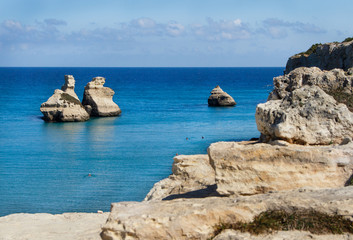 Fototapeta na wymiar The Two Sisters stacks in front of the shore of Torre dell'Orso