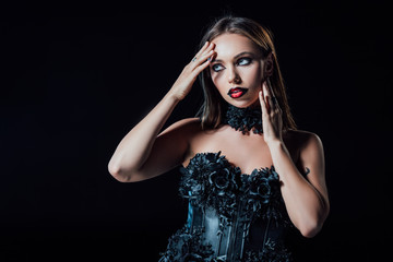 scary vampire girl in black gothic dress isolated on black