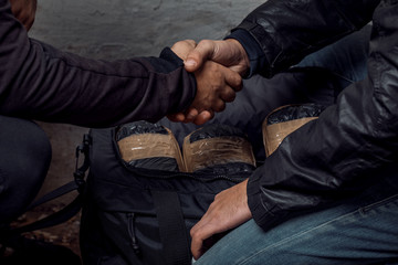 A person with money buys a dose of cocaine or heroin or other drug from a drug dealer