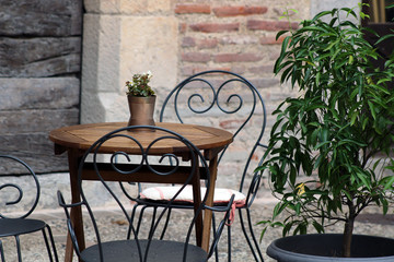 Table en bois dans le patio, jardin, avec siège en fer forgé