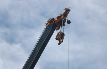 crane boom with hooks isolated on sky background