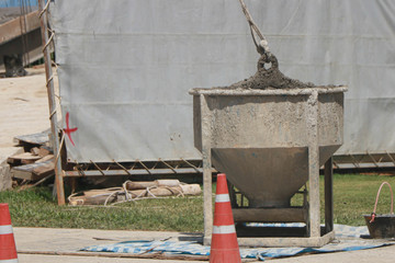 Fototapeta na wymiar The crane lifts the bowl with cement to a height.