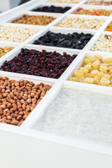 various nuts, dried fruits and berries in a wooden box in the shop window